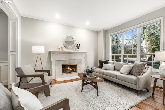 living room with hardwood / wood-style floors, crown molding, and a fireplace