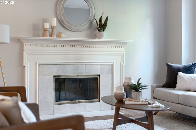 living room with a tiled fireplace and ornamental molding