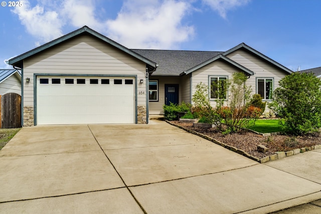 654 Wilson Ave, Cottage Grove, OR 97424 - ranch-style house featuring fence, a garage, stone siding, and driveway