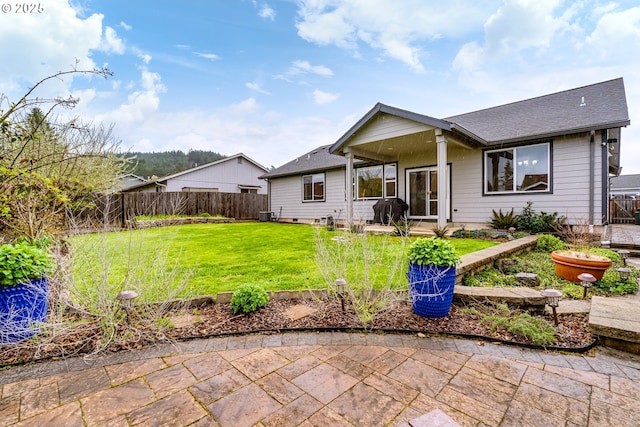 654 Wilson Ave, Cottage Grove, OR 97424 - back of house with a fenced backyard, a patio area, a shingled roof, and a yard