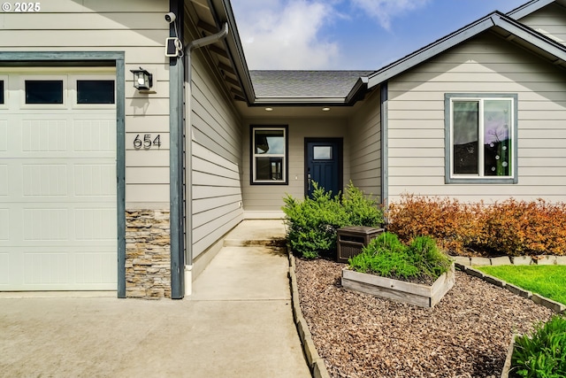 654 Wilson Ave, Cottage Grove, OR 97424 - property entrance with stone siding, a shingled roof, and a garage
