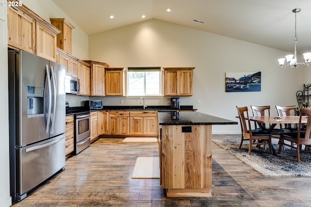 654 Wilson Ave, Cottage Grove, OR 97424 - kitchen featuring wood finished floors, high vaulted ceiling, stainless steel appliances, light brown cabinets, and a notable chandelier