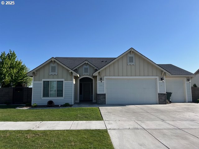 101 Rome St, Boardman, OR 97818 - ranch-style house with a garage, board and batten siding, concrete driveway, and a front yard