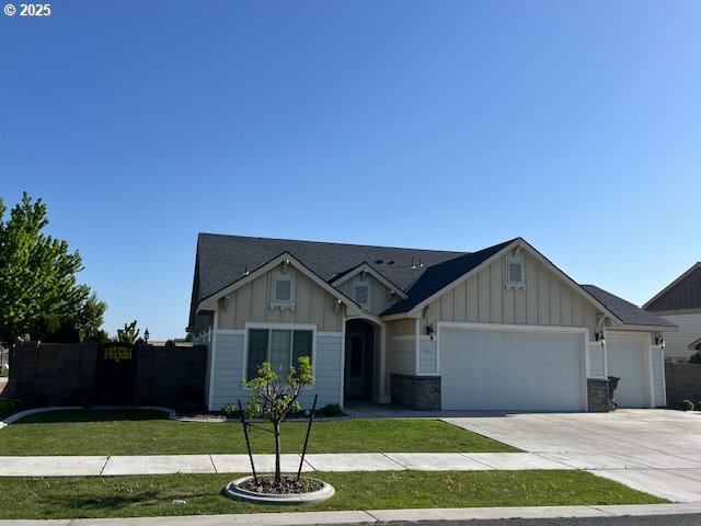 101 Rome St, Boardman, OR 97818 - ranch-style home featuring board and batten siding, a garage, fence, a front lawn, and concrete driveway