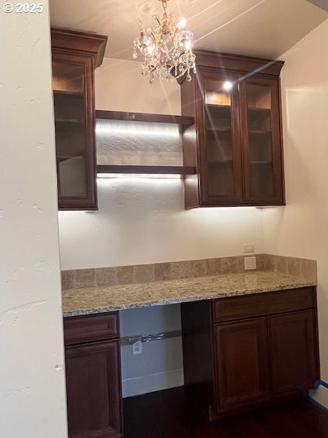 101 Rome St, Boardman, OR 97818 - kitchen with a chandelier, light stone countertops, and glass insert cabinets