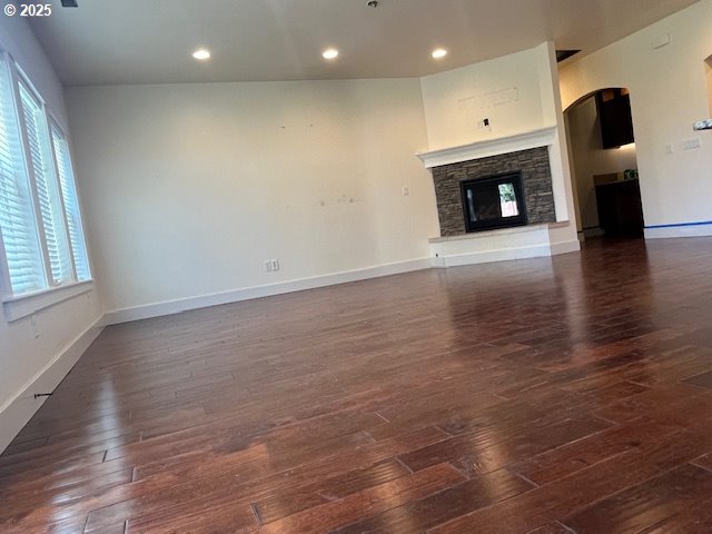 101 Rome St, Boardman, OR 97818 - unfurnished living room with dark wood-style flooring, baseboards, recessed lighting, and a fireplace