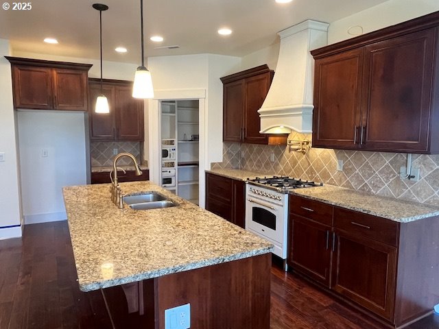 101 Rome St, Boardman, OR 97818 - kitchen featuring dark wood finished floors, a sink, light stone counters, custom range hood, and white appliances