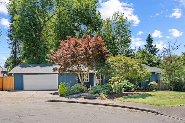 9142 SW Raritan Ct, Tualatin, OR 97062 - view of property hidden behind natural elements with an attached garage, concrete driveway, and board and batten siding