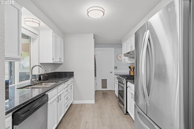 9142 SW Raritan Ct, Tualatin, OR 97062 - kitchen featuring stainless steel appliances, a sink, under cabinet range hood, light wood-style floors, and white cabinetry