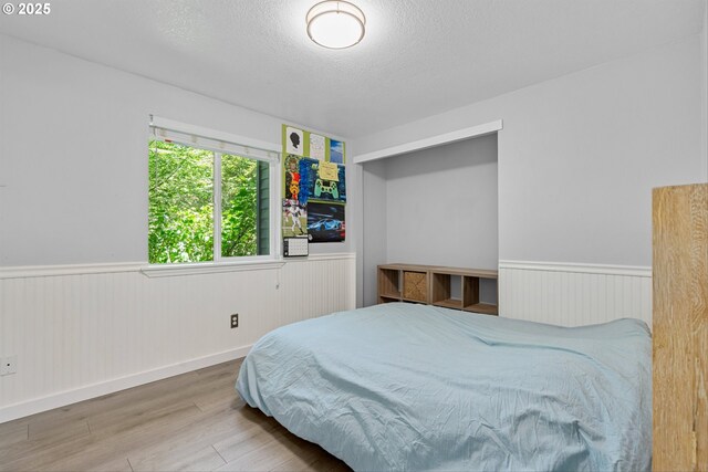 9142 SW Raritan Ct, Tualatin, OR 97062 - bedroom with wainscoting, wood finished floors, and a textured ceiling