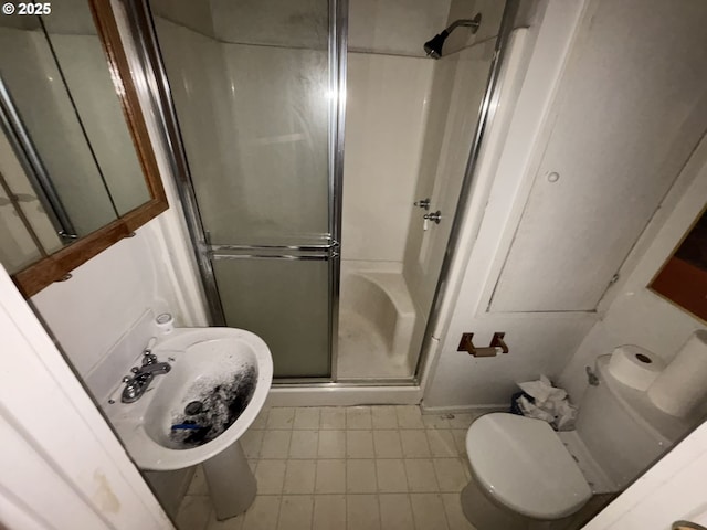 bathroom featuring a stall shower and toilet