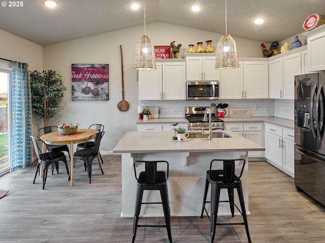 kitchen with sink, decorative light fixtures, white cabinets, and appliances with stainless steel finishes