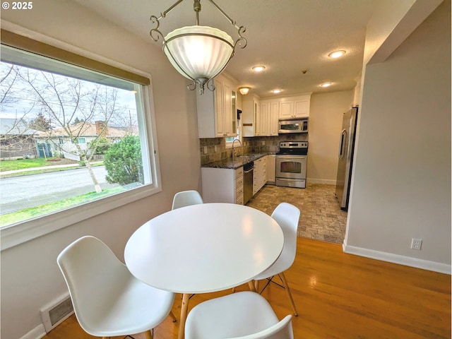 dining space with visible vents, recessed lighting, baseboards, and light wood-style floors