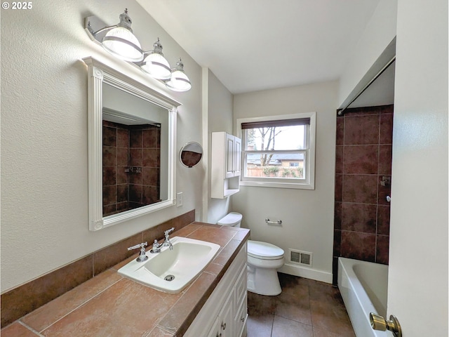 bathroom with vanity, baseboards, visible vents, tile patterned floors, and toilet