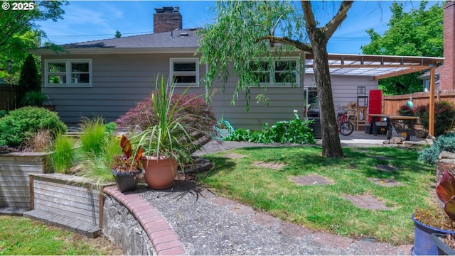 back of property with a patio, fence, a yard, a pergola, and a chimney