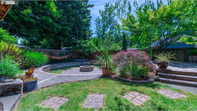 view of yard featuring a patio, a fire pit, and a fenced backyard