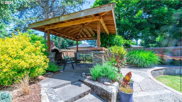 view of property's community featuring a gazebo, fence, and a patio