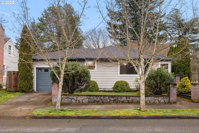 ranch-style home with concrete driveway, fence, a garage, and roof with shingles