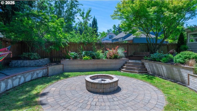 view of patio featuring a fenced backyard and an outdoor fire pit