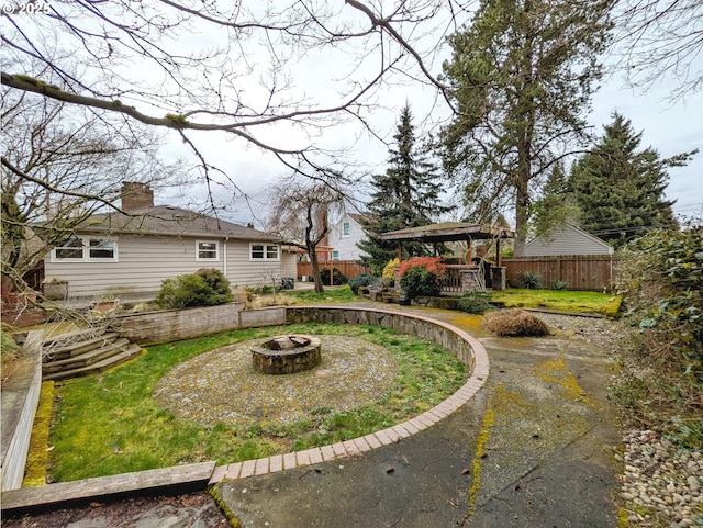 view of yard with a fire pit and fence