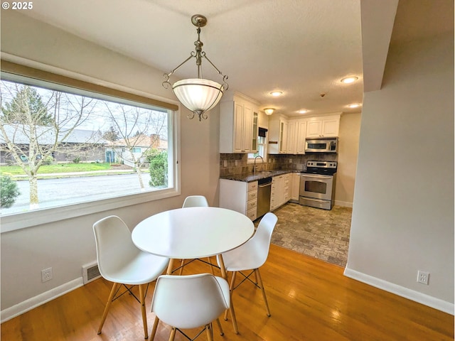 dining space with visible vents, recessed lighting, wood finished floors, and baseboards