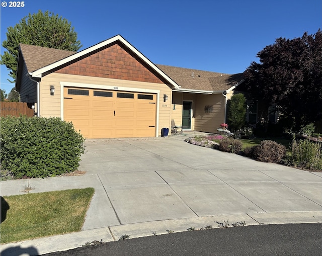 ranch-style home with an attached garage, concrete driveway, and a shingled roof
