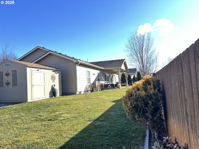 view of side of property with a yard and a storage shed