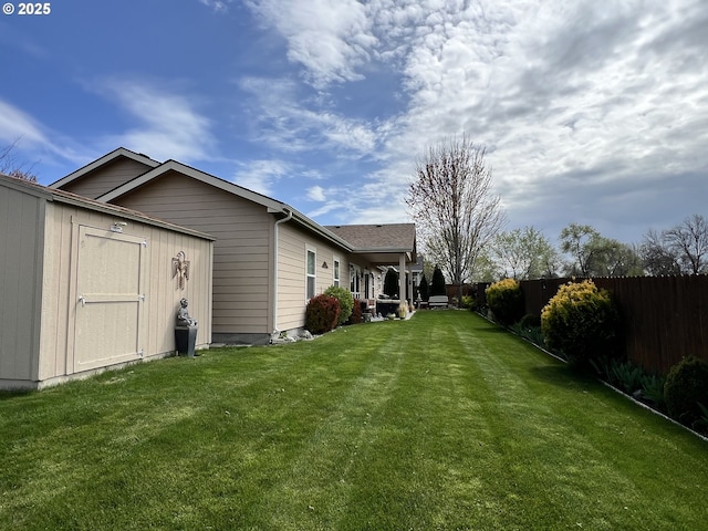 view of yard featuring a storage unit and an outbuilding