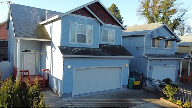 traditional-style house featuring concrete driveway, fence, and a garage