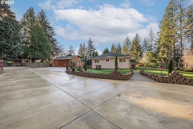 view of front of property with a garage, an outdoor structure, and a front lawn