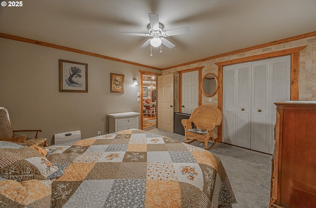 bedroom with crown molding, light colored carpet, ceiling fan, and two closets