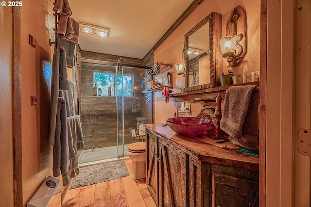 bathroom with vanity, toilet, an enclosed shower, and hardwood / wood-style floors