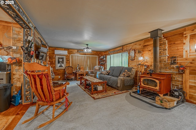 living room with carpet, a wood stove, wooden walls, and a wall unit AC