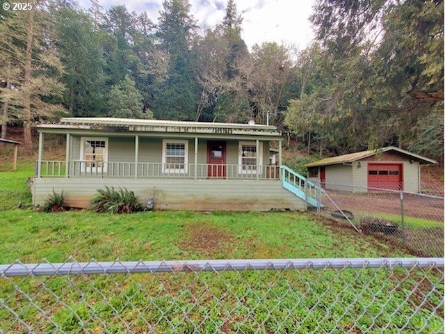 view of front of home featuring covered porch, a front lawn, and an outdoor structure