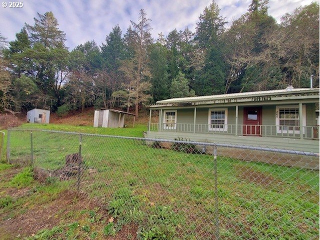 view of front of house with a front yard and a storage unit