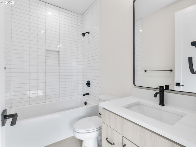 full bathroom featuring tiled shower / bath, vanity, and toilet