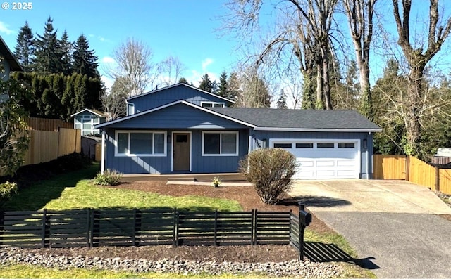 view of front of home with a garage, a fenced front yard, and concrete driveway