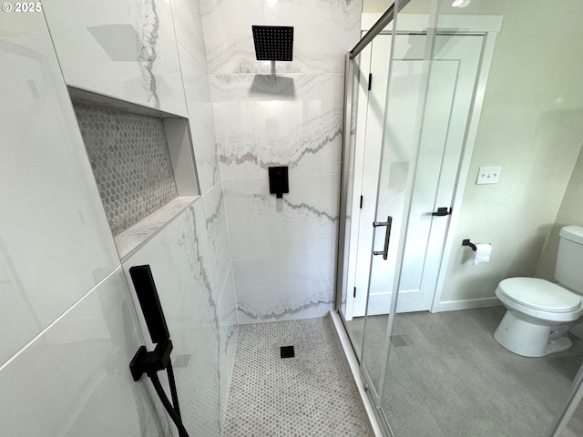 bathroom featuring a stall shower, baseboards, and toilet