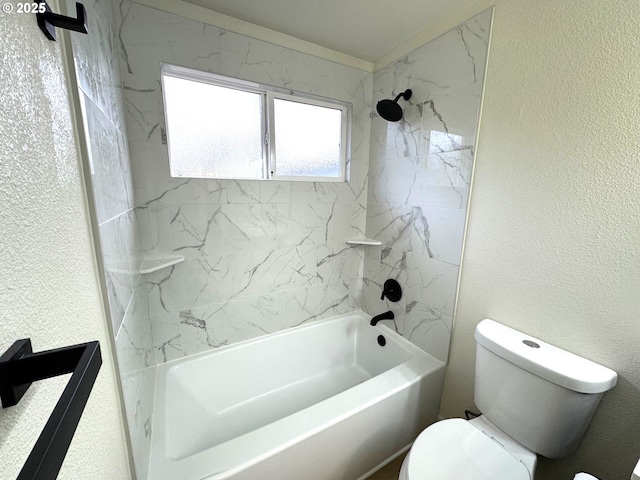 bathroom featuring a textured wall, shower / bathing tub combination, and toilet