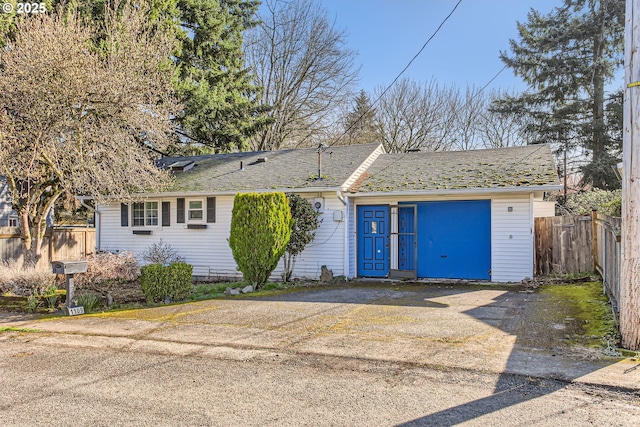 ranch-style home with roof with shingles and fence