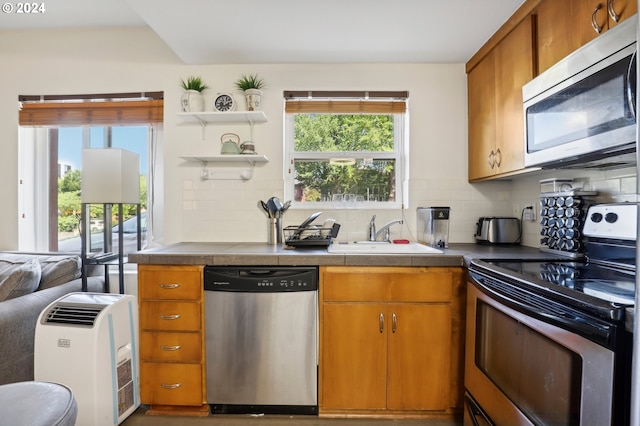 kitchen featuring open shelves, stainless steel appliances, tile counters, backsplash, and a sink