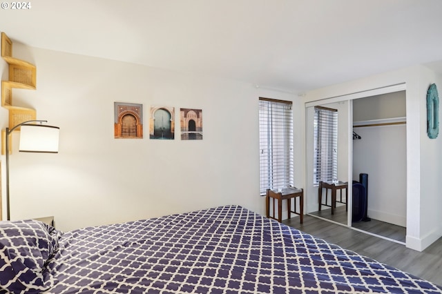 bedroom with dark wood-style floors, a closet, and baseboards