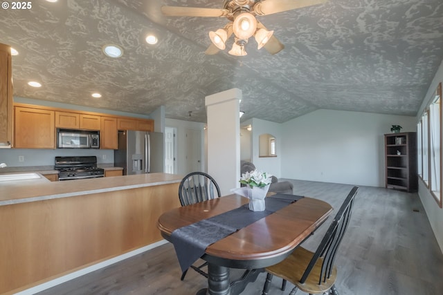 dining room with dark wood-style floors, lofted ceiling, ceiling fan, and a textured ceiling