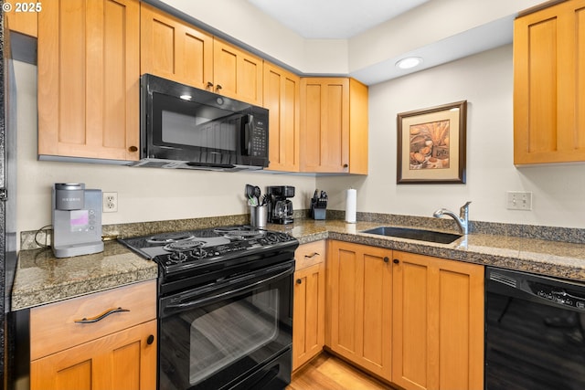 kitchen featuring sink, black appliances, and light wood-type flooring