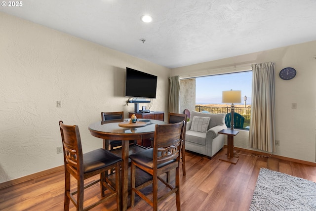 dining space featuring hardwood / wood-style flooring and a textured ceiling