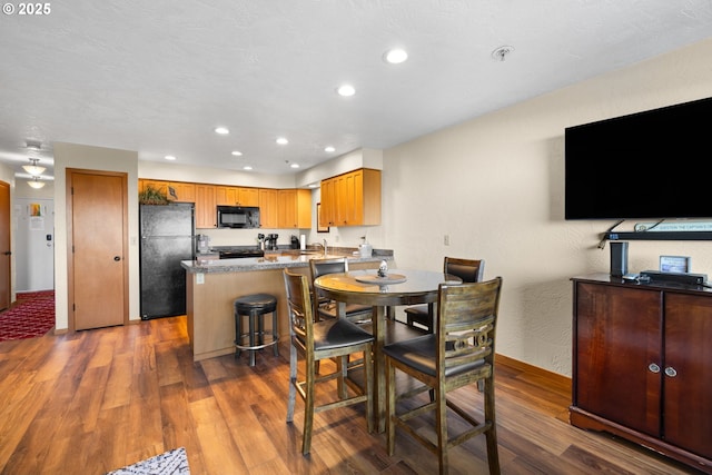 dining area with dark hardwood / wood-style floors and sink