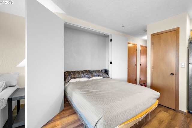 bedroom with hardwood / wood-style floors and a textured ceiling