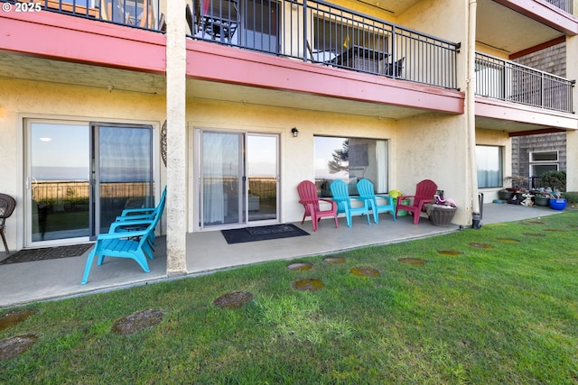 rear view of house with a patio and a lawn