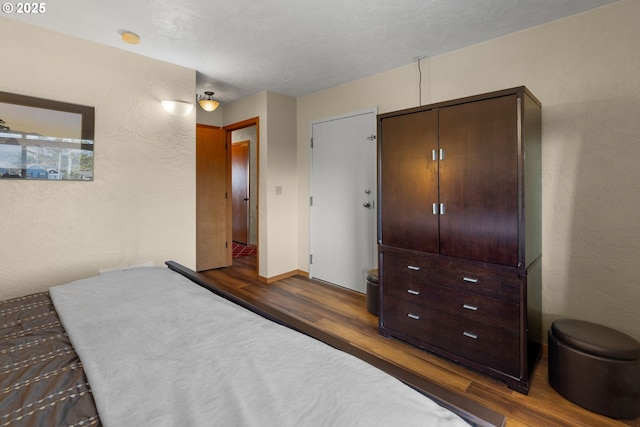 bedroom with dark wood-type flooring