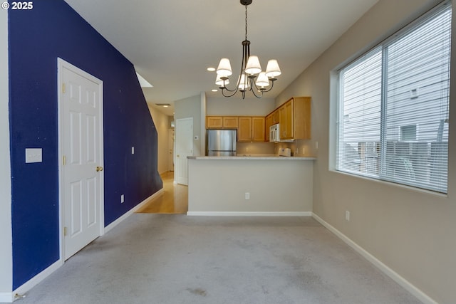 4338 NE 76th Ave, Portland, OR 97218 - kitchen featuring freestanding refrigerator, a chandelier, light colored carpet, light countertops, and pendant lighting